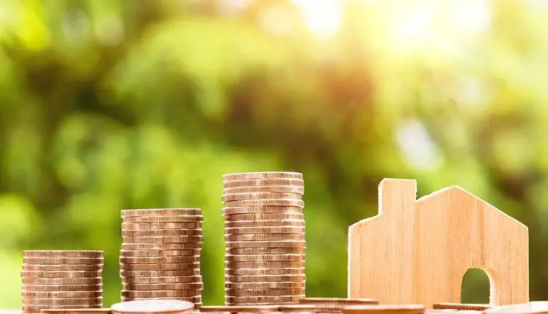 Small house on a table with coins
