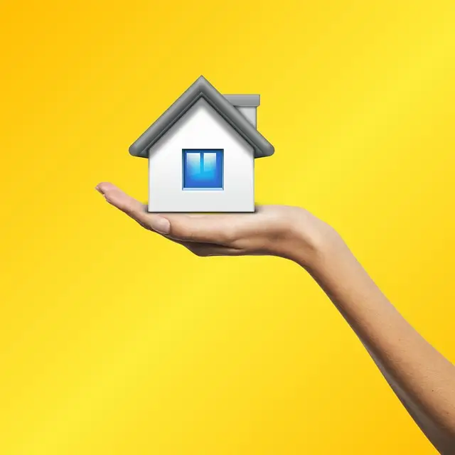 Hand holding house with yellow background representing accurate valuation