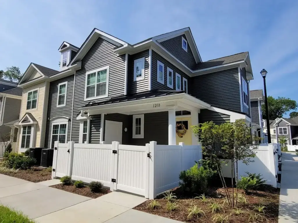 Gray coastal-style homes with white porches and fencing