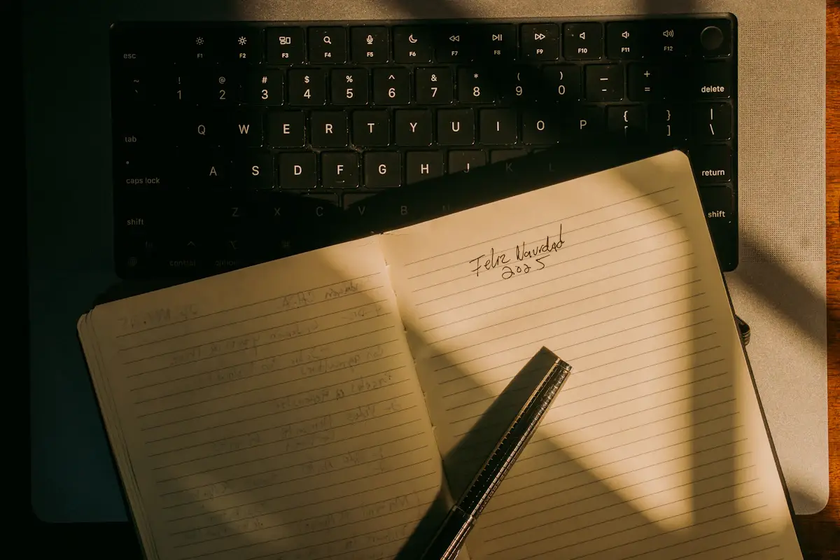 Open notebook and pen resting on a laptop keyboard
