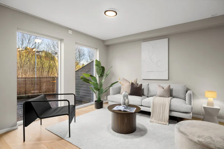 Furnished living room with a sofa, chairs and large windows