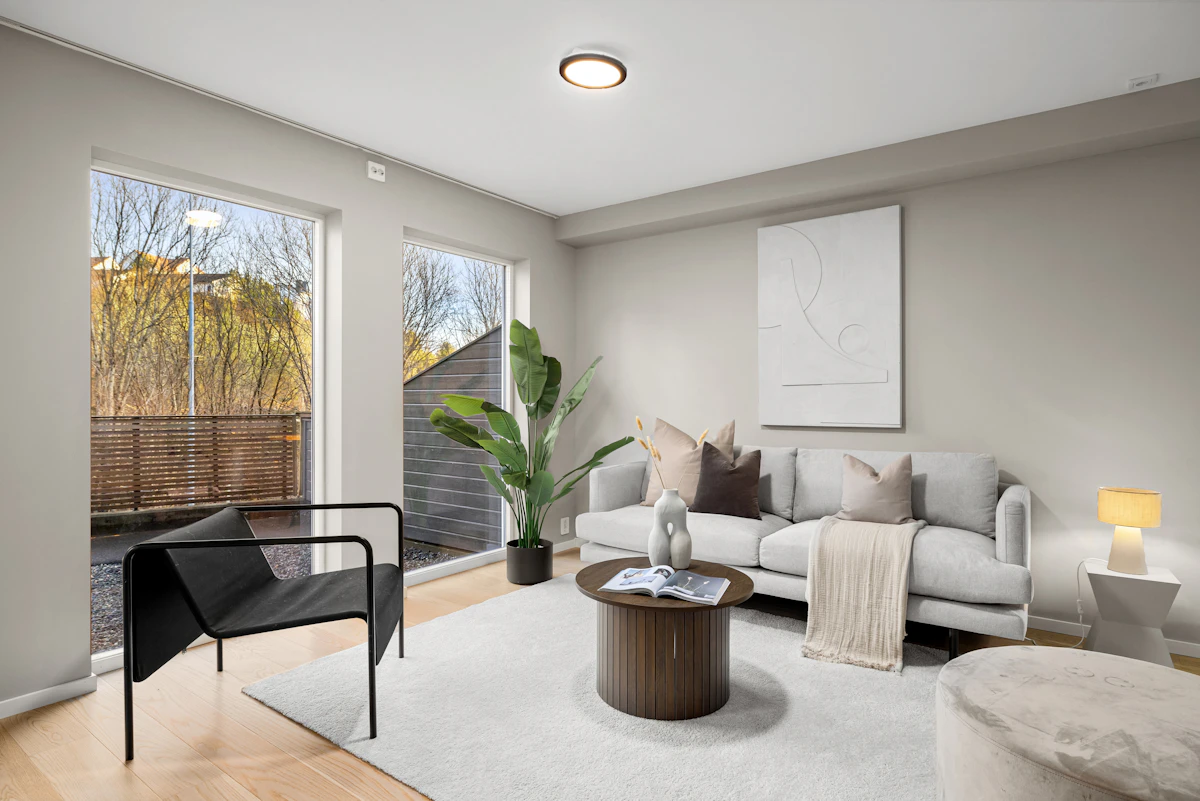 Furnished living room with a sofa, chairs and large windows