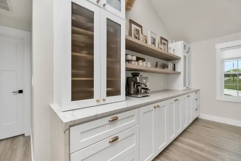 White kitchen cabinetry with glass-front upper cabinets