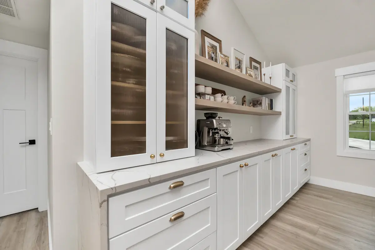 White kitchen cabinetry with glass-front upper cabinets