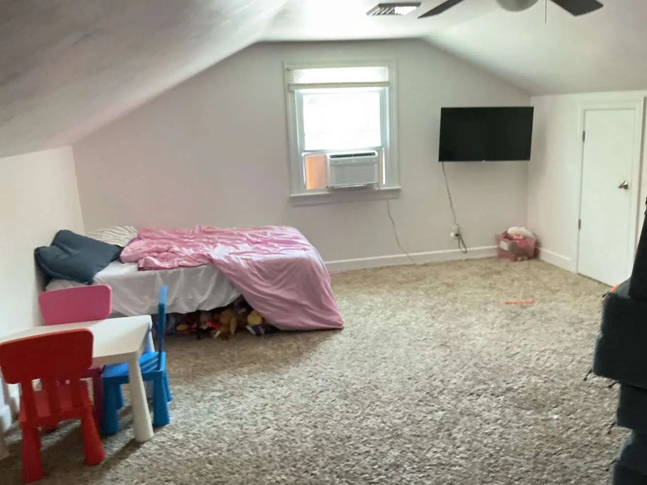 Carpeted upper room with sloping ceilings, low sidewalls and a central window