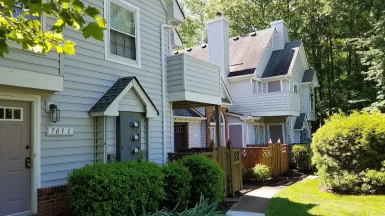 Attached gray residences beside a landscaped walkway