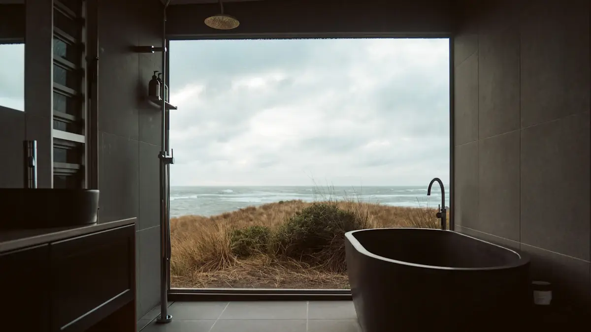 Freestanding bathtub beside a large window overlooking the coast