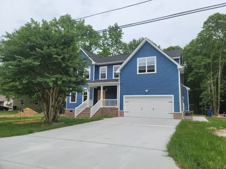Blue two-story home with a white garage and covered front porch