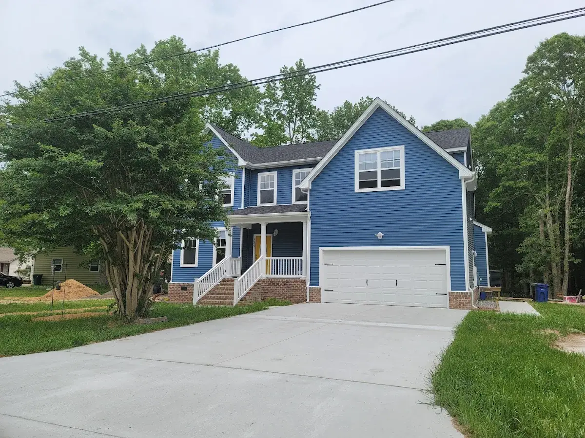 Blue two-story house with a white garage and covered front porch.