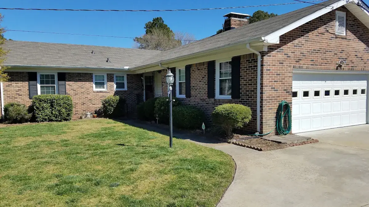 Brick ranch home with a curved walkway and attached white garage