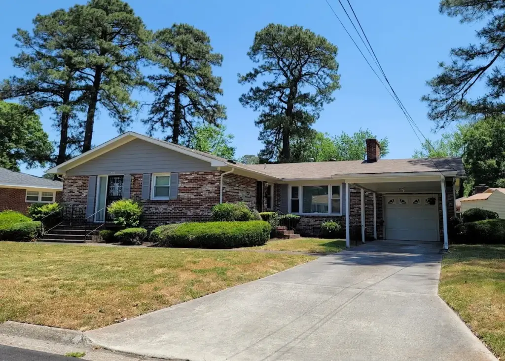 Brick ranch home with a curved driveway and attached garage