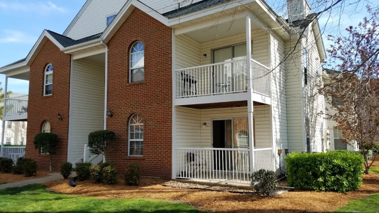 Brick residential building with stacked white balconies