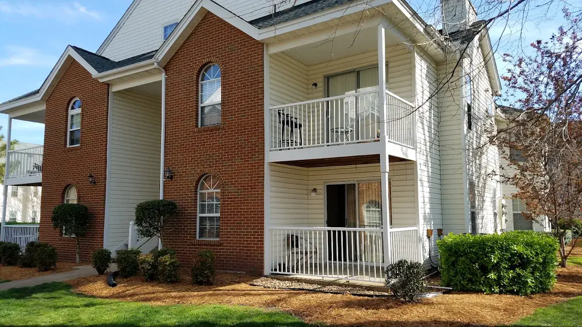 Brick residential building with stacked white balconies