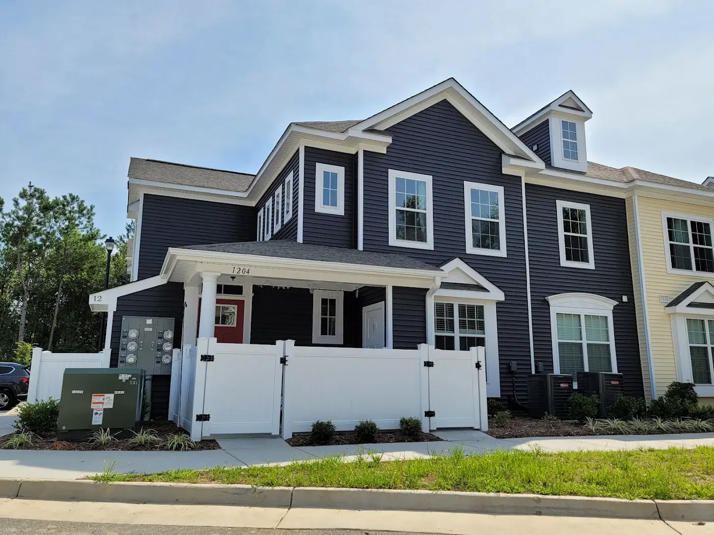 Dark blue house with white trim and a covered front porch