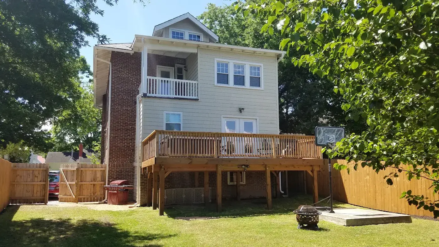Rear of a house with an elevated wooden deck and doors on different levels