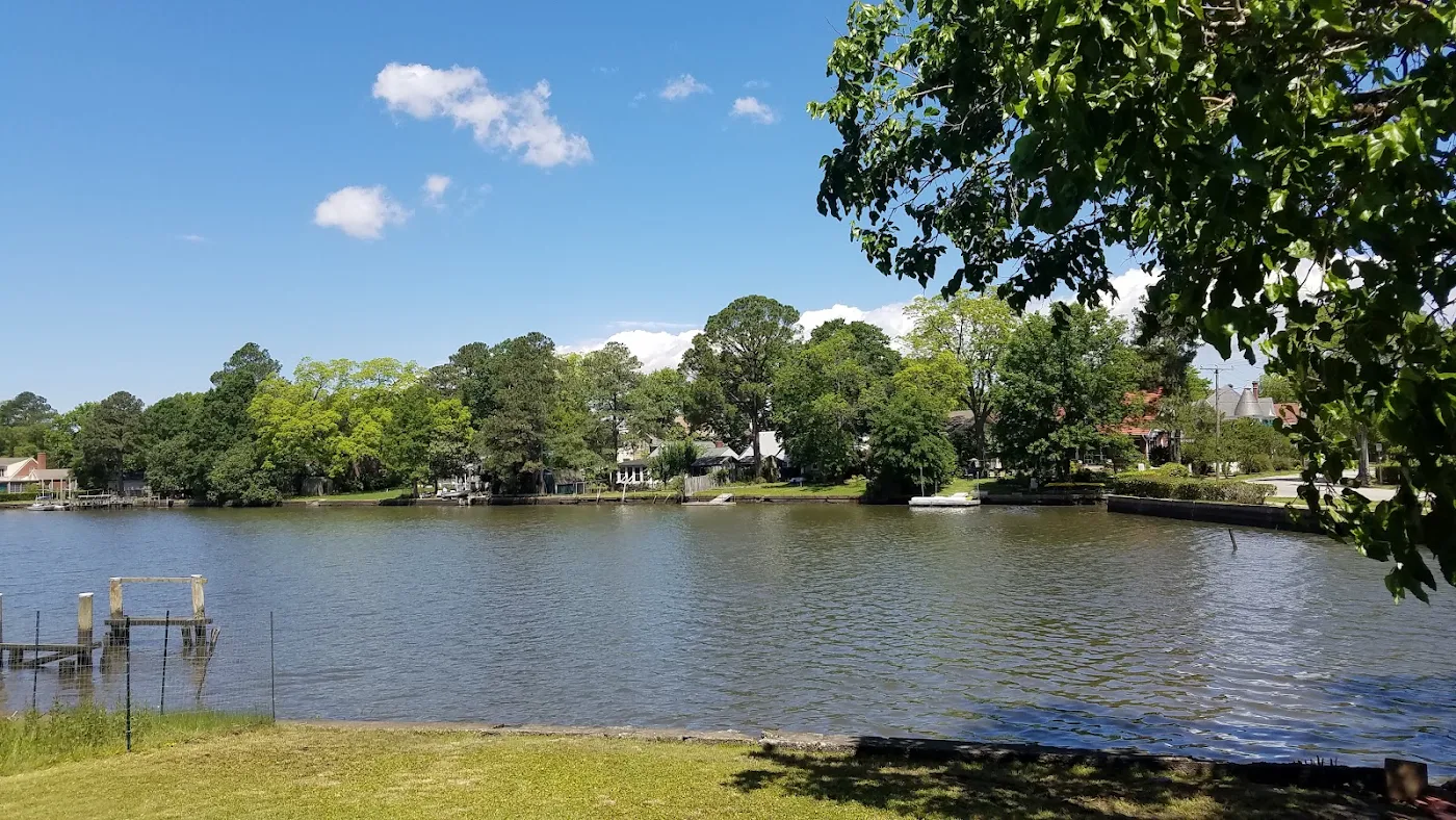 View across the water toward houses, trees and small docks