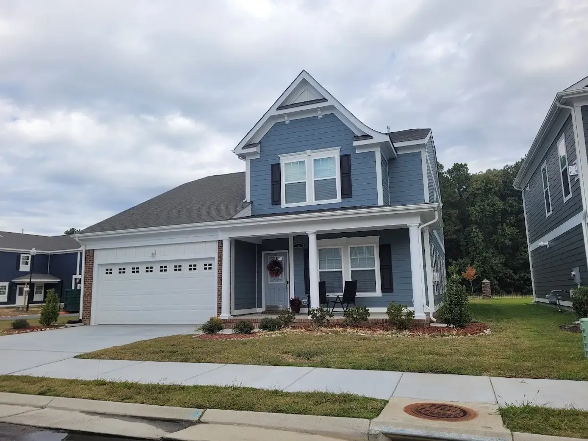 Gray two-story residence with a white double garage and front porch