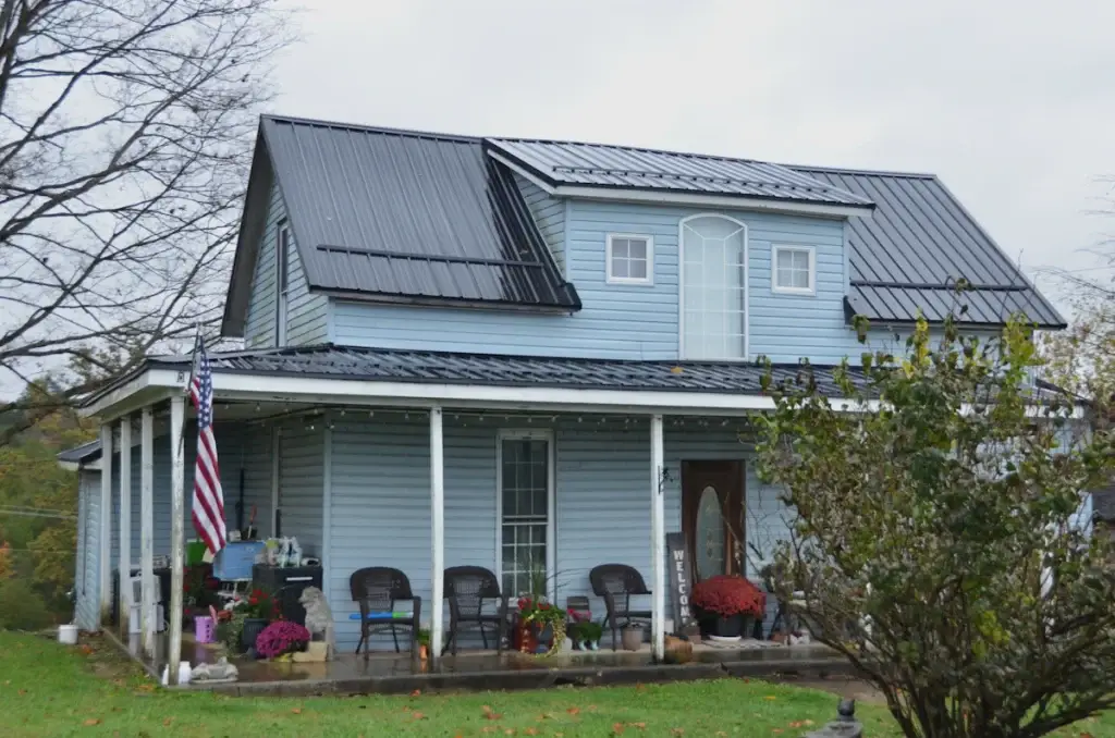 Light-blue house with a covered front porch and metal roof