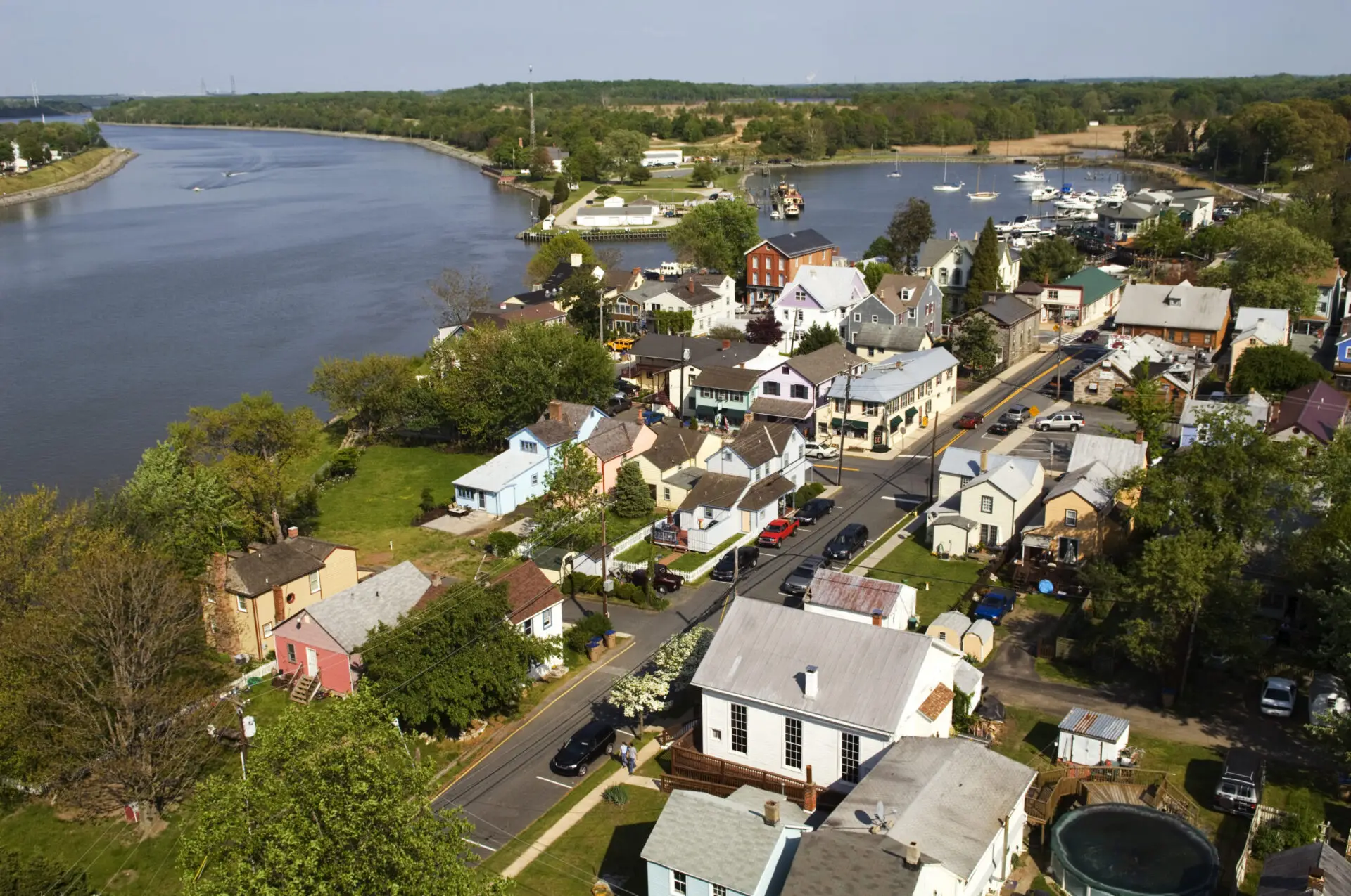 Aerial view of homes and wooded lots beside a winding waterway